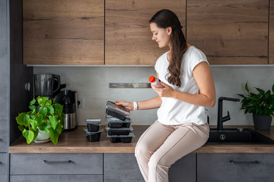 Side view of young woman using mobile phone