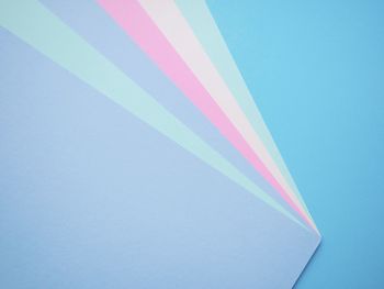 Low angle view of multi colored paper against blue sky