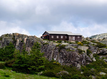 Plants and rocks by building against sky