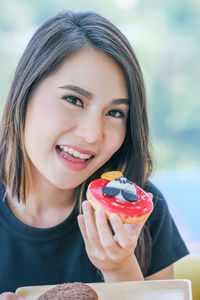 Young asian woman enjoy eating couple of sweet colorful donut