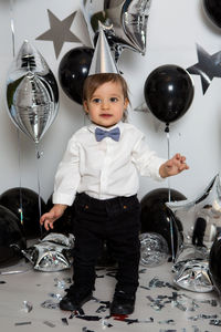 Boy in black clothes on his birthday party with balloon and silver stars