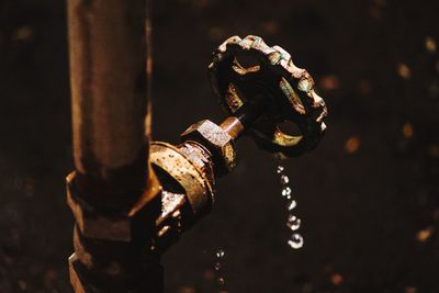 Close-up of rusty pipe with valve at night