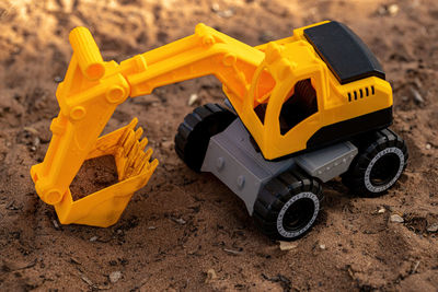 Close-up of yellow toy car on sand