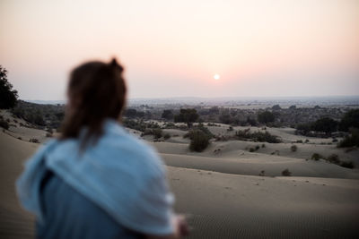 Rear view of woman looking at sunset