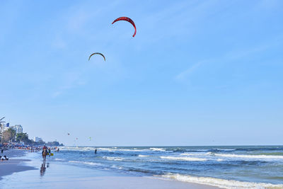 People on beach by sea against sky