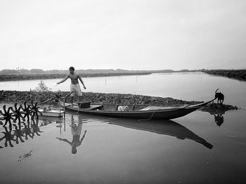 Man standing on lake against sky