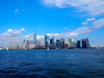 City at waterfront against cloudy sky