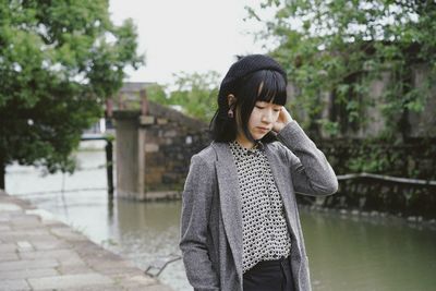 Young woman standing against wall