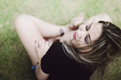 High angle view of beautiful woman sitting on field at park