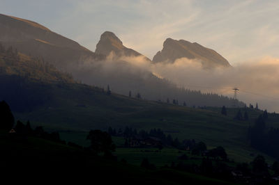 Scenic view of field and mountains against sky