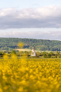 Scenic view of grassy field against cloudy sky