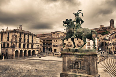 Statue of historical building against cloudy sky