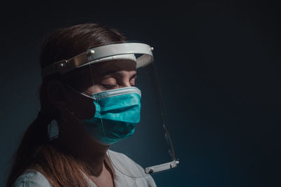 Female doctor with mask and face shield closed eyes