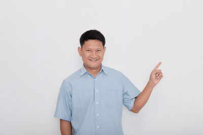 Portrait of smiling man standing against white background