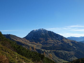 Scenic view of mountains against blue sky