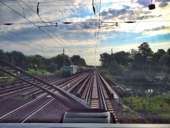 Railroad tracks against cloudy sky