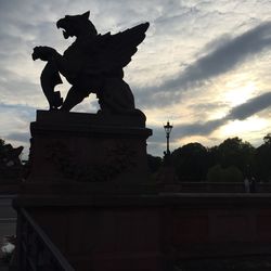 Silhouette statue against sky in city