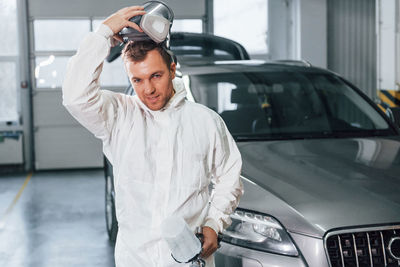 Job is done. man in uniform is working in the auto service.