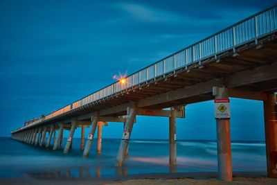 Silhouette pier over sea against sky