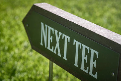 Close-up of arrow sign on grass