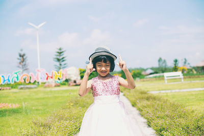 Portrait of smiling girl standing on field