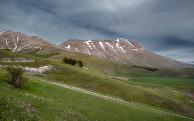 Scenic view of mountains against cloudy sky