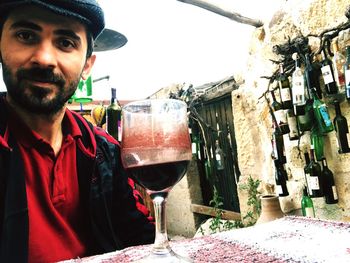 Portrait of young man drinking glass