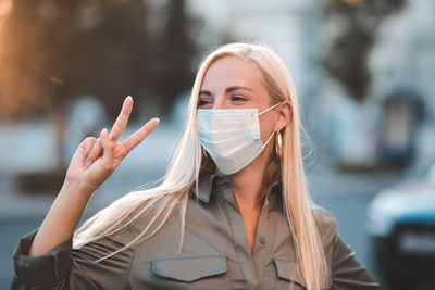 Young woman wearing mask gesturing