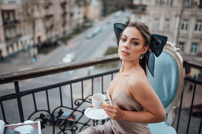 Portrait of woman with coffee standing in city