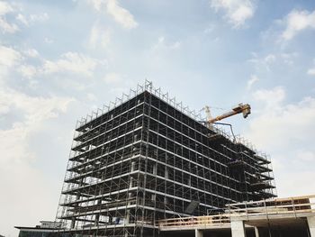 Low angle view of building under construction against sky