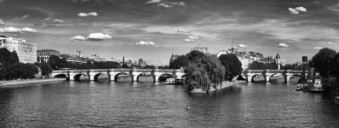 Bridge over river in city against sky