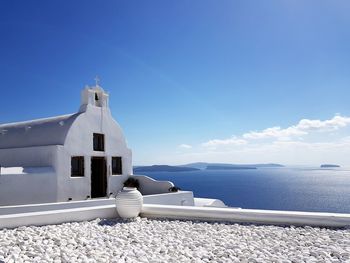 Building by sea against blue sky