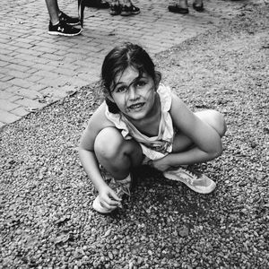 High angle portrait of girl crouching at playground