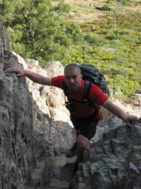 Full length of smiling young woman on cliff