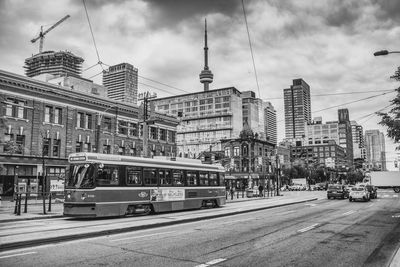 Tram on city street against sky