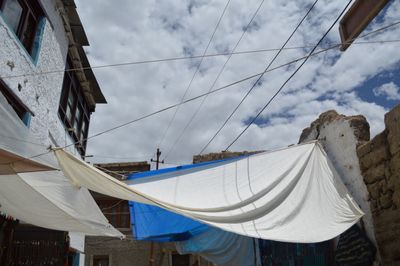 Low angle view of clothes drying against sky