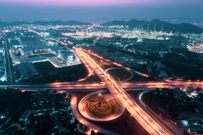 High angle view of illuminated street amidst buildings in city at night