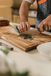 Midsection of man preparing food on cutting board