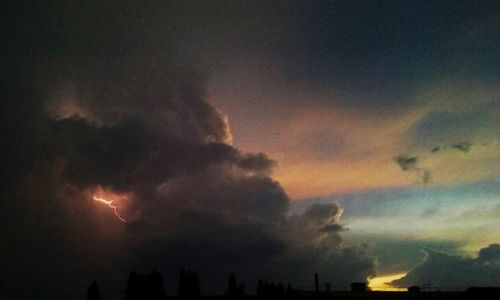 Low angle view of storm clouds at sunset