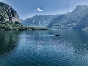 Scenic view of lake by mountains against sky