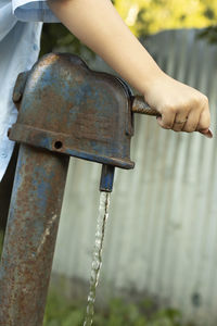 Close-up of woman hand on metallic structure in park