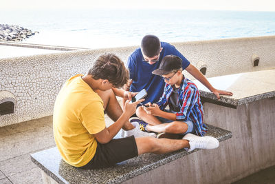 Teenagers using smartphone together. smiling teens browsing social media online. boys watching video