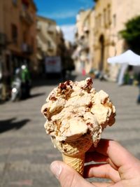 Close-up of hand holding ice cream cone