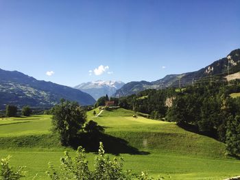 Scenic view of field and mountains against clear sky