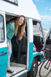 Woman standing at entrance of camper van