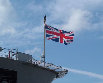 Low angle view of flag on building against sky