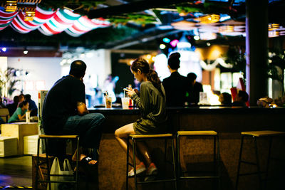 Rear view of people sitting at bar