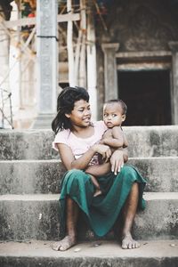 Full length of women sitting on staircase