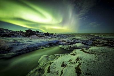 Scenic view of sea against dramatic sky at night