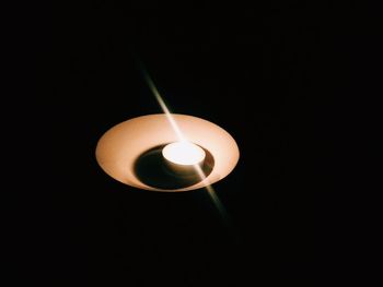 Close-up of lit candle against black background